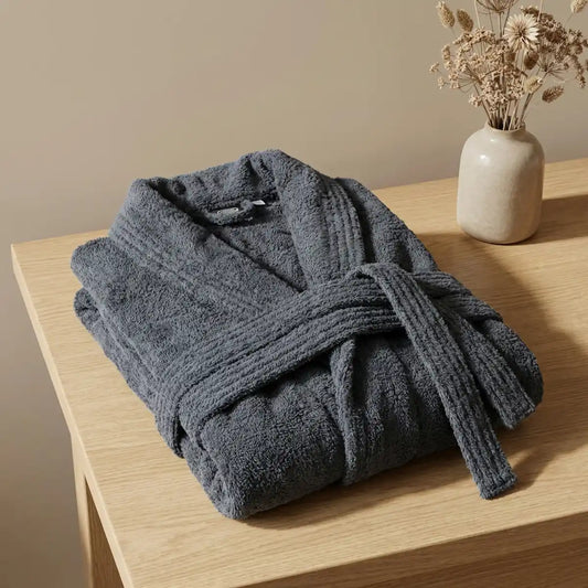 Primer plano del tejido de algodón peinado del albornoz gris oscuro, mostrando su suavidad y acabado premium sin impurezas.