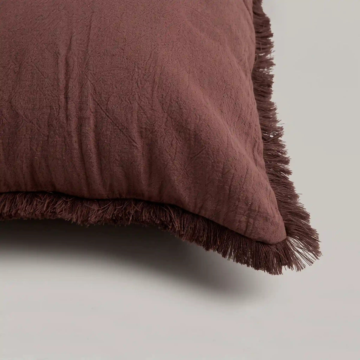 Primer plano del tejido extrasuave y transpirable 100% algodón de la funda de cojín roja de Omahome, destacando su calidad natural.