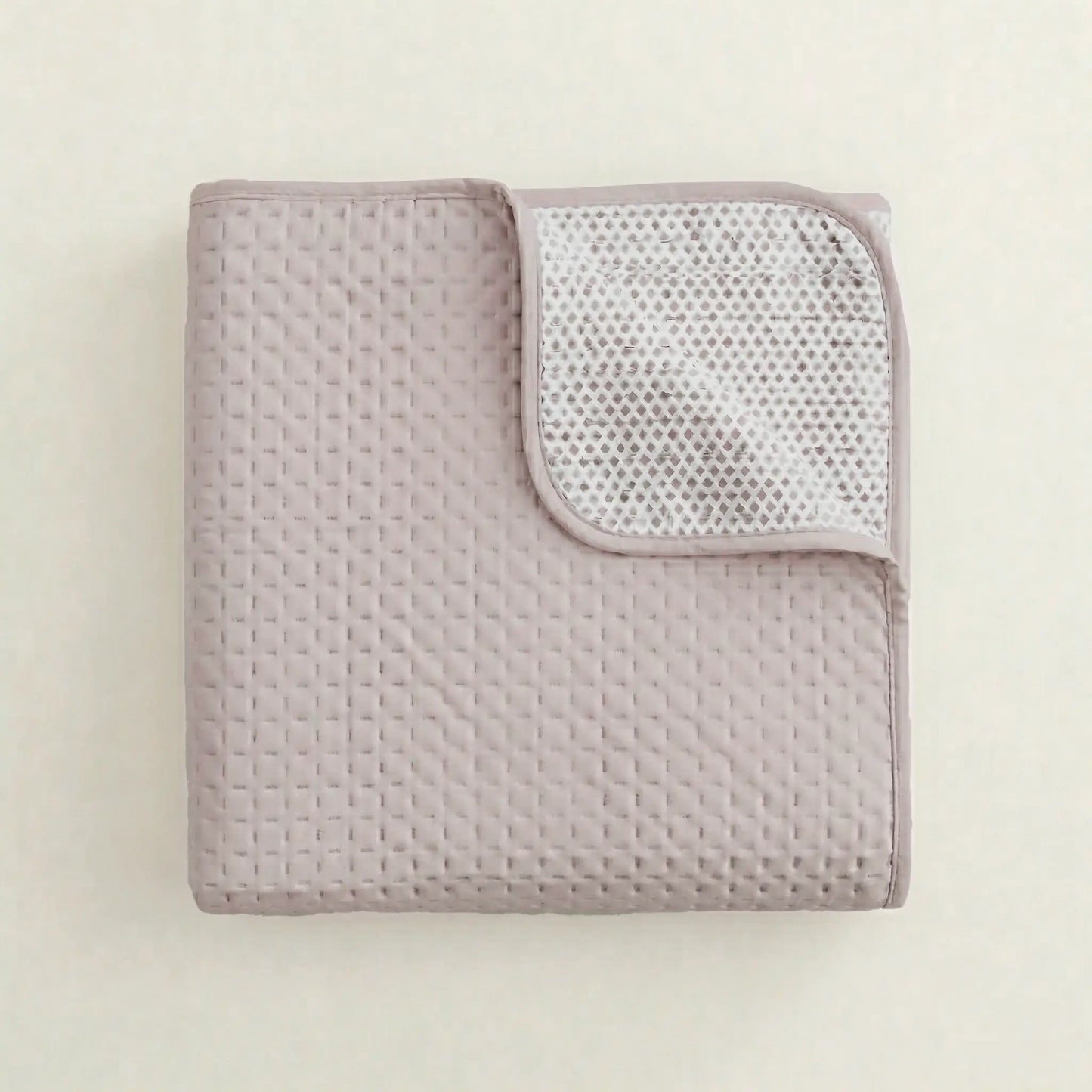 Textura y costuras del acolchado fino de la colcha de verano malva