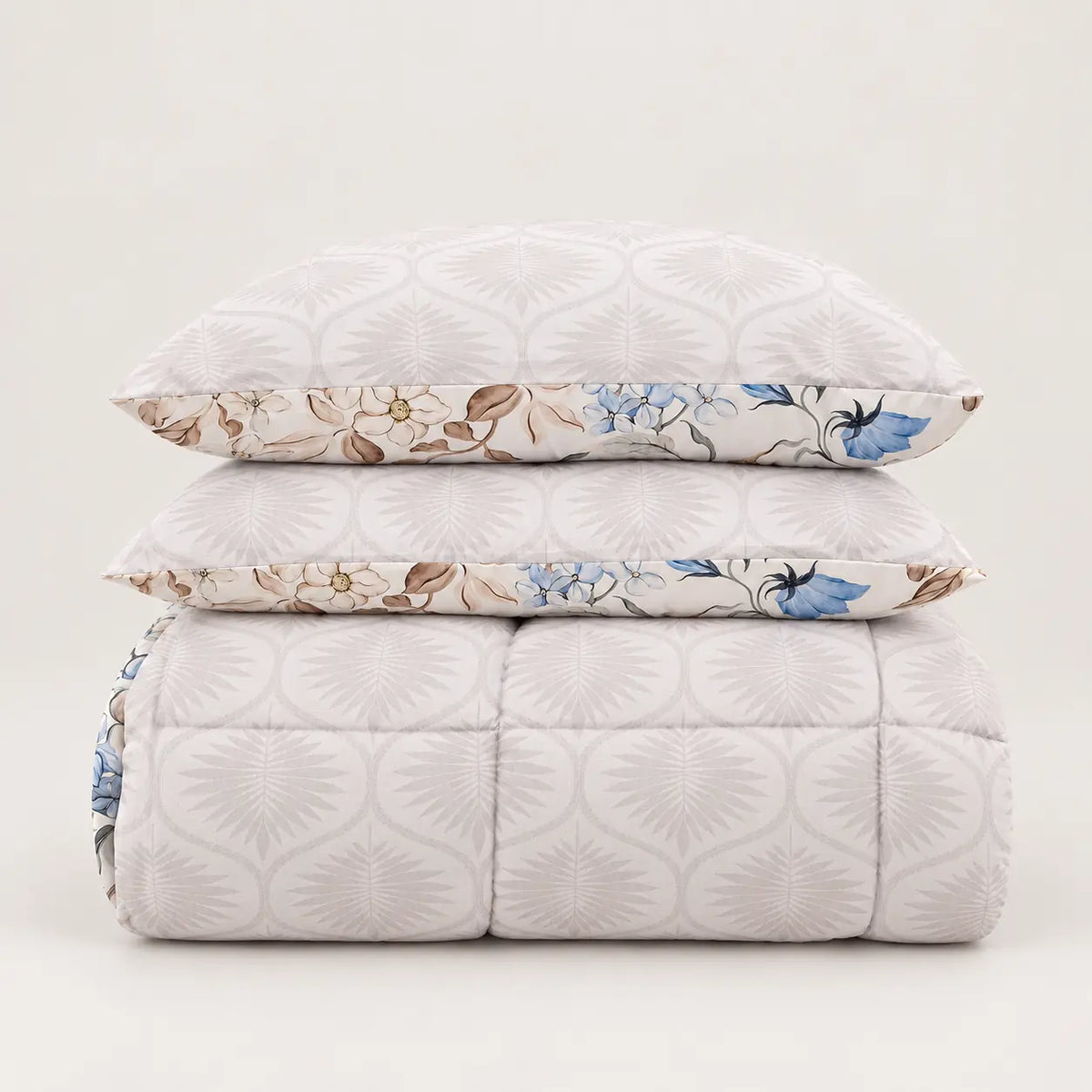 Detalle de las dos caras del edredón reversible, mostrando el estampado principal floral azul y el diseño complementario en el reverso.