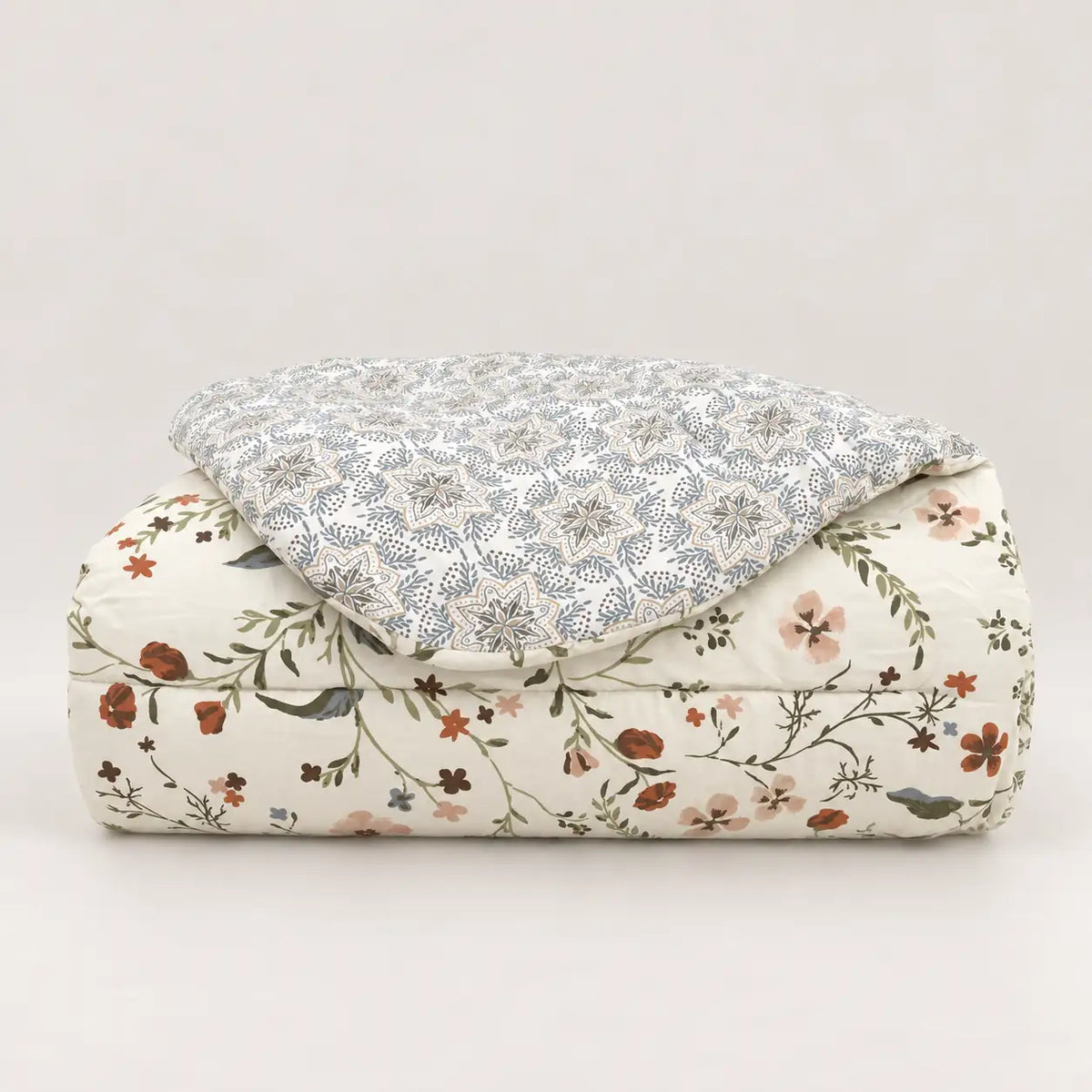 Mid-season duvet neatly folded, showing wildflowers on the front and a geometric pattern on the reverse.