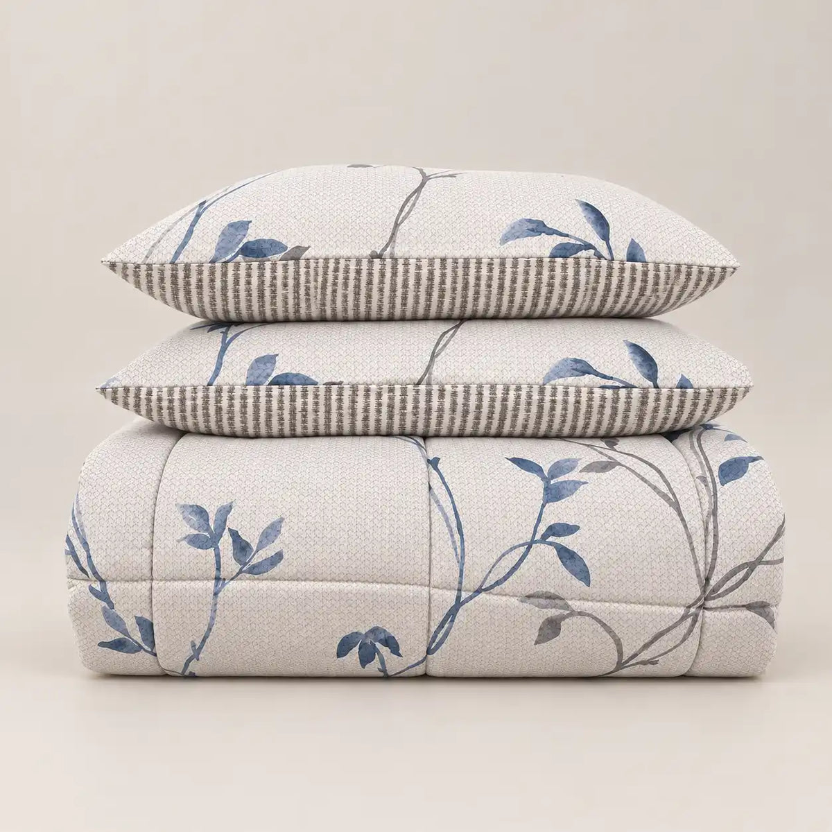Winter duvet with a blue floral print and striped reverse, neatly folded with two matching pillowcases.