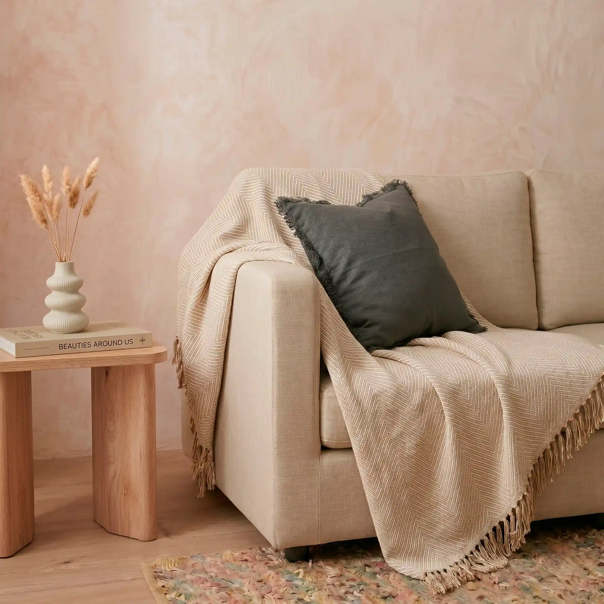 Combinación de cojines decorativos en el sofá, resaltando la elegante funda gris oscuro de algodón natural con flecos de Omahome.
